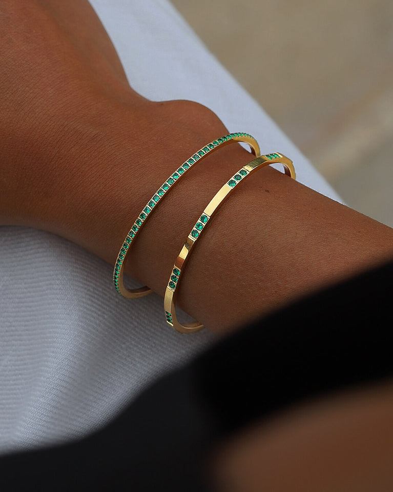 A Bangle in 14k gold-plated 316L stainless steel with green stones from Waldor & Co. One size. The model is Opulent Bangle Polished.