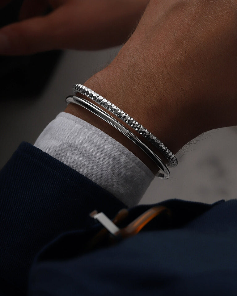 A polished stainless steel bangle in silver from Waldor & Co. One size. The model is Noble Bangle Polished