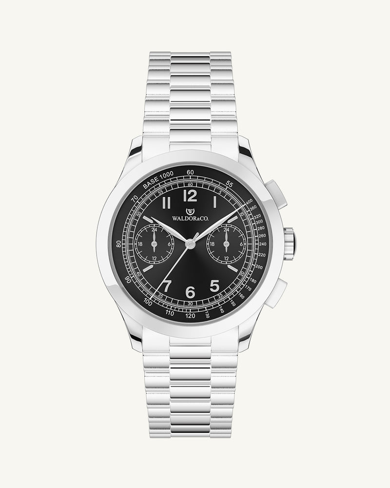 A round mens watch in rhodium-plated silver from Waldor & Co. with black sunray dial and a second hand. Seiko movement. The model is Chrono 39 Porto Cervo.