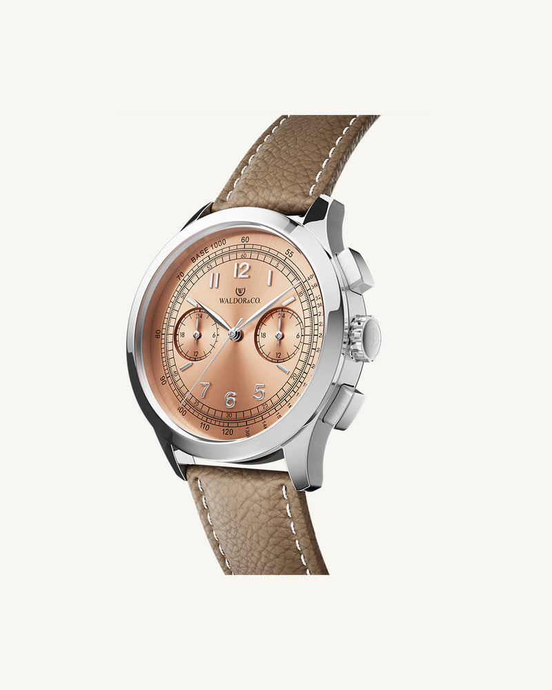 A round mens watch in Rhodium-plated 316L stainless steel with from Waldor & Co. with Salmon sunray dial in brass sunray and a second hand. Seiko movement. Genuine leather strap. The model is Chrono 39 Porto Cervo Ltd. Edition.