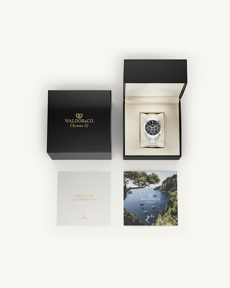 A round mens watch in rhodium-plated silver from Waldor & Co. with black sunray dial and a second hand. Seiko movement. The model is Chrono 42 Capri 42mm.