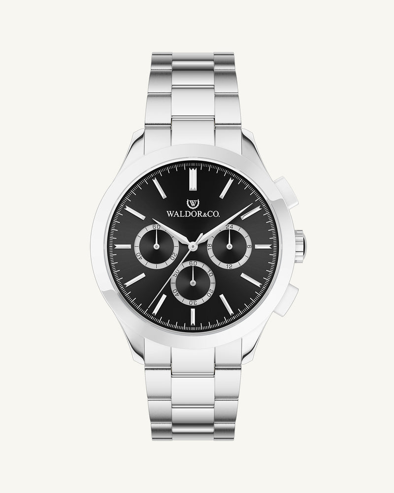 A round mens watch in rhodium-plated silver from Waldor & Co. with black sunray dial and a second hand. Seiko movement. The model is Chrono 42 Capri 42mm.
