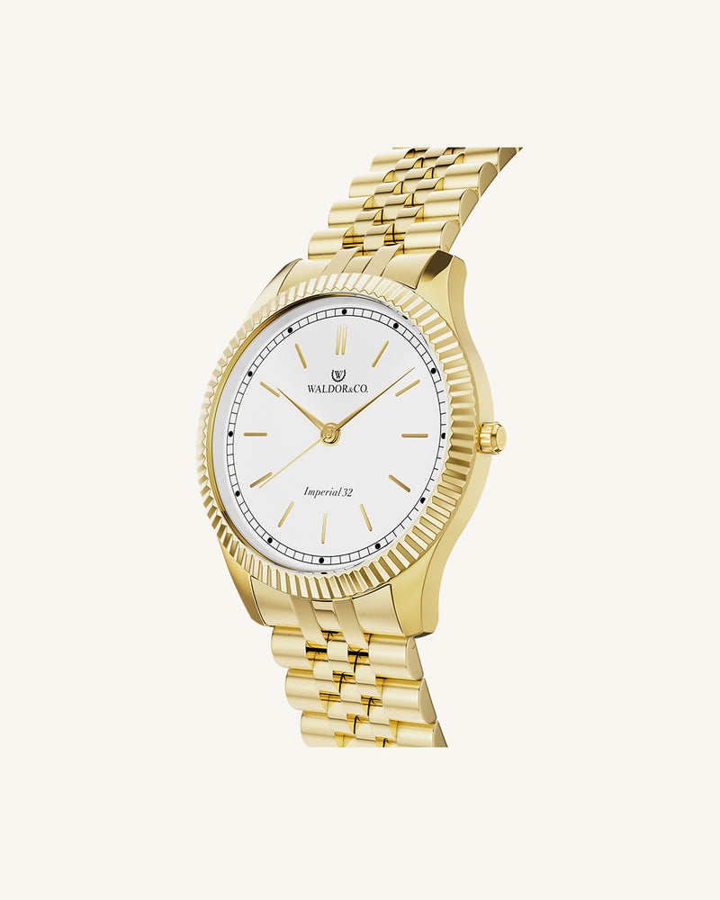 A round womens watch in 14k gold from Waldor & Co. with white sunray dial and a second hand. Seiko movement. The model is Imperial 32 Positano 32mm.