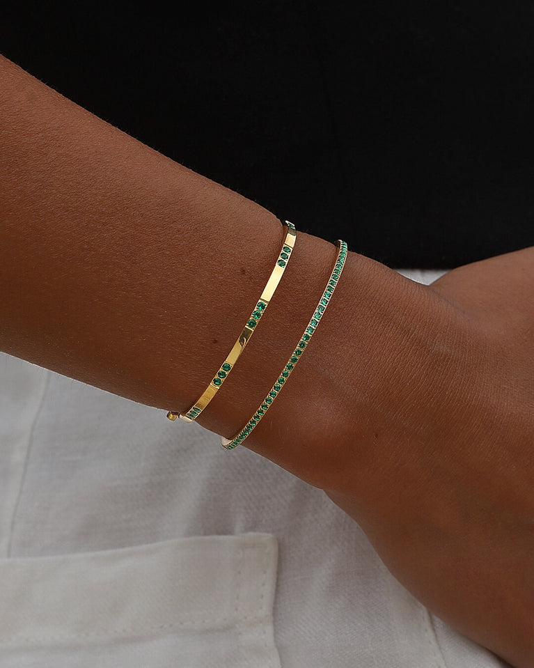 A Bangle in 14k gold-plated 316L stainless steel with green stones from Waldor & Co. One size. The model is Opulent Bangle Polished.