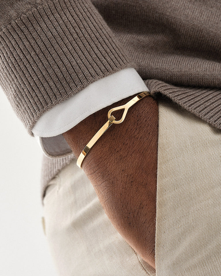 A Bangle Bracelet in 14k gold-plated from Waldor & Co. The model is Signature Bangle Polished Gold