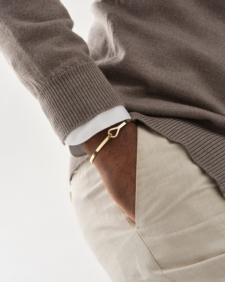 A Bangle Bracelet in 14k gold-plated from Waldor & Co. The model is Signature Bangle Polished Gold