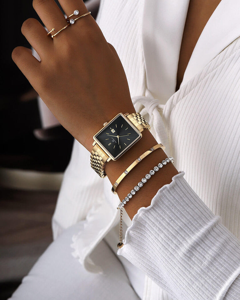 A square womens watch in 14k gold from Waldor & Co. with black sunray dial and a second hand. Seiko movement. The model is Delight 32 Chelsea 28x32mm.