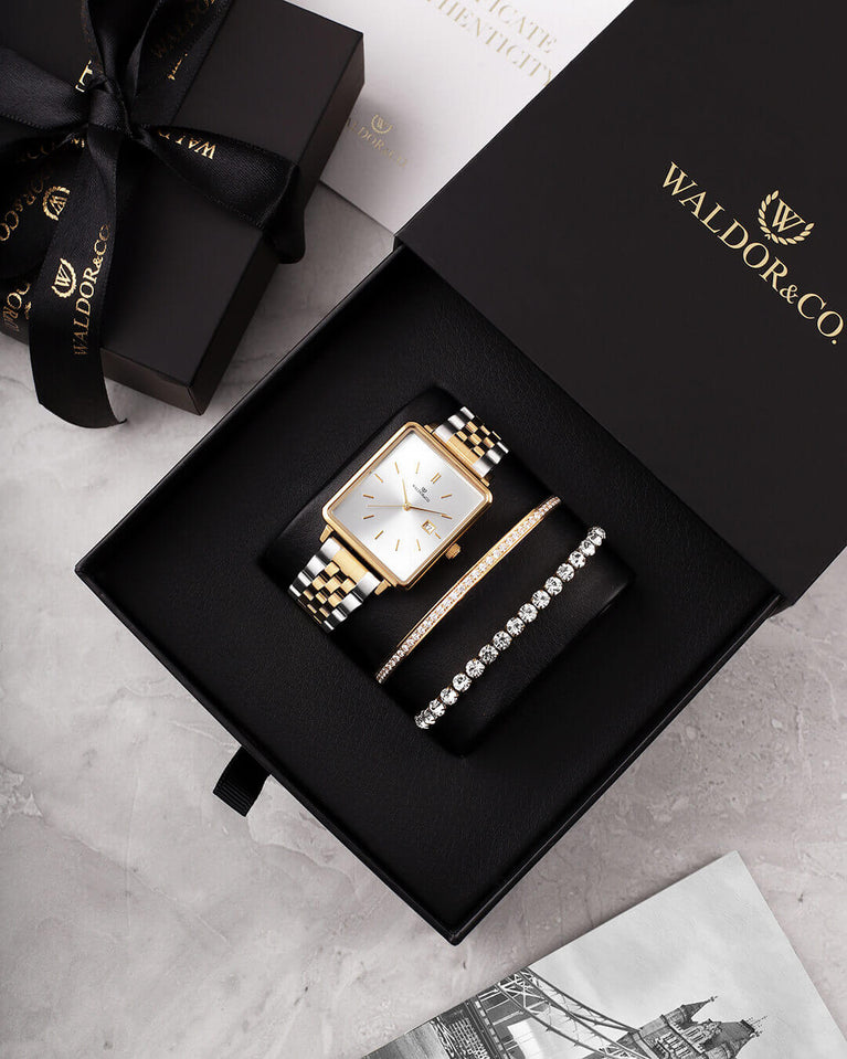 A square womens watch in silver and 14k gold from Waldor & Co. with silver sunray dial and a second hand. Seiko movement. The model is Delight 32 Chelsea 28x32mm.